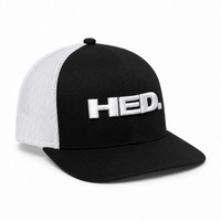 The HED. Trucker Snapback Hat – Black & White features a black and white mesh design, an adjustable snapback closure, and a curved bill. The front panel displays “HED.” in large, raised white letters.