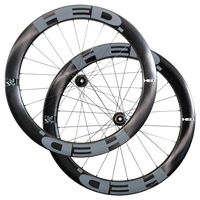 Two HED Vanquish V62 Carbon Aero Wheels in black and gray, featuring deep-section, aerodynamic carbon rims, are shown overlapping against a plain white background—an ideal high-performance wheelset for triathlon riders.