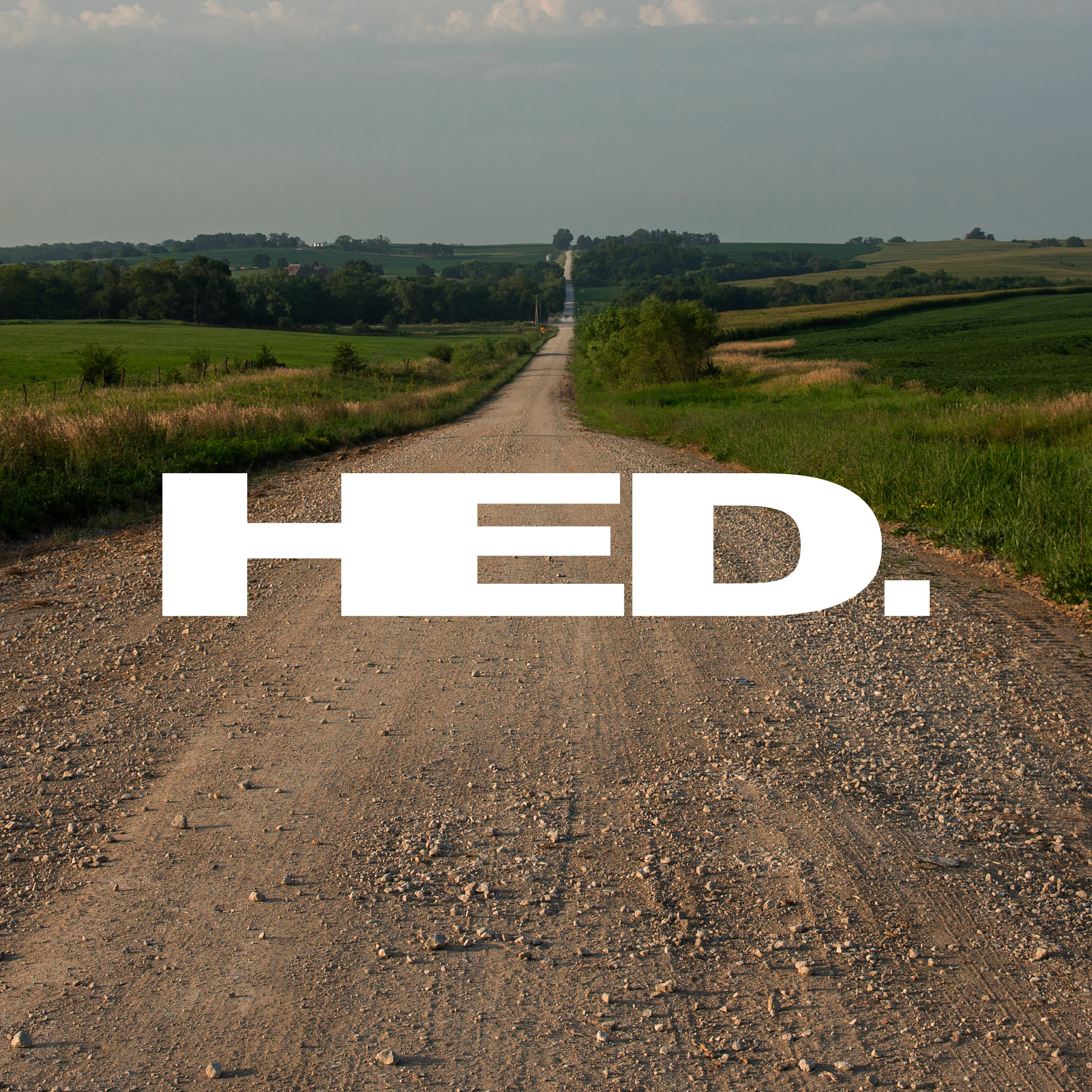 Gravel road leading into a field with 'HED.' text overlay