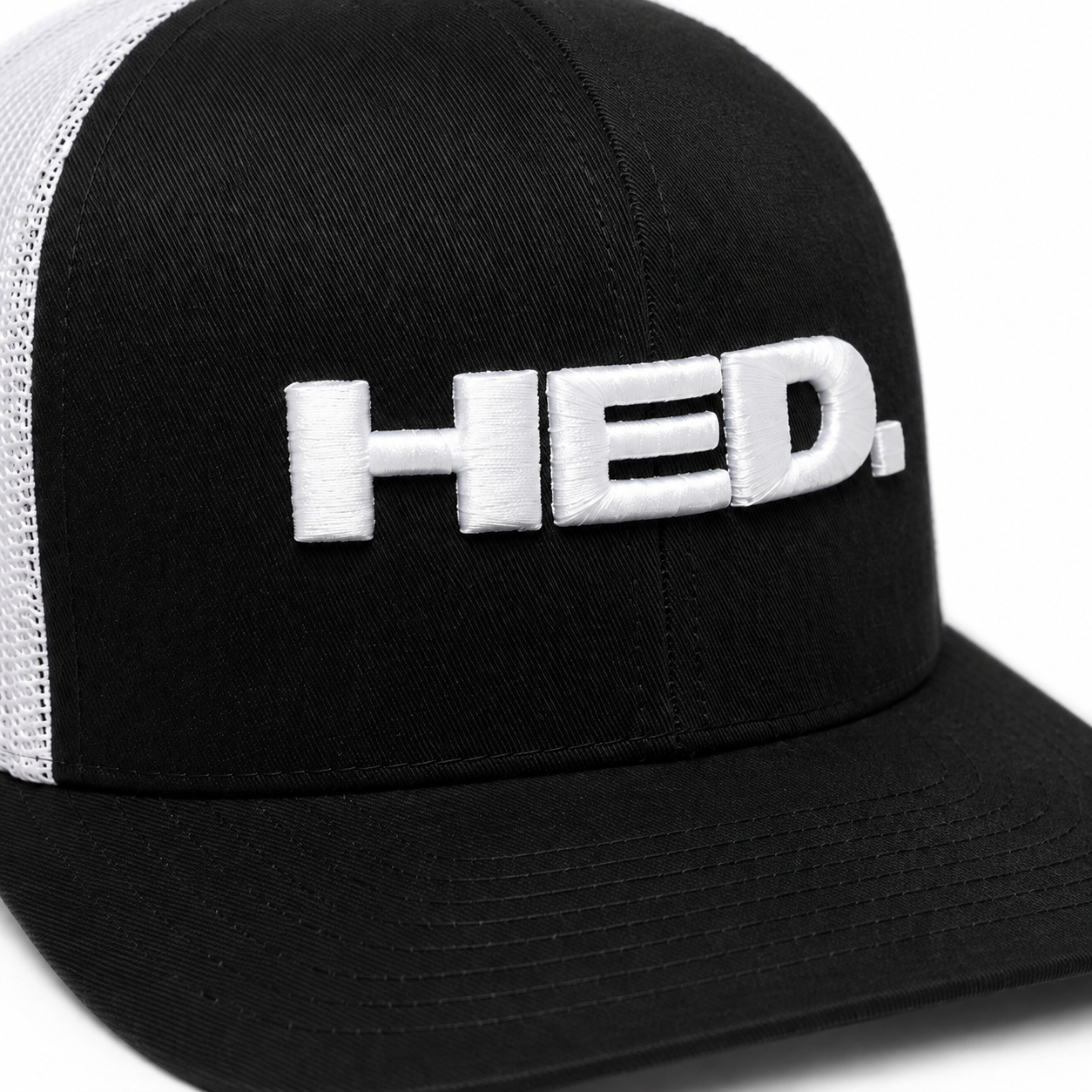 The HED. Trucker Snapback Hat – Black & White features a classic black and white mesh design with the word “HED.” embroidered in large white letters on the front. This hat offers an adjustable fit for ultimate comfort and style.