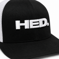 The HED. Trucker Snapback Hat – Black & White features a classic black and white mesh design with the word “HED.” embroidered in large white letters on the front. This hat offers an adjustable fit for ultimate comfort and style.