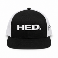 The HED. Trucker Snapback Hat – Black & White is an adjustable black and white trucker hat, featuring “HED.” embroidered in white on the front and a signature on the left side panel.