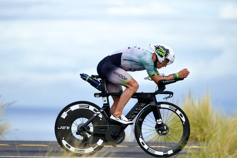 Triathlete racing on a time trial bike with HED aerodynamic wheels